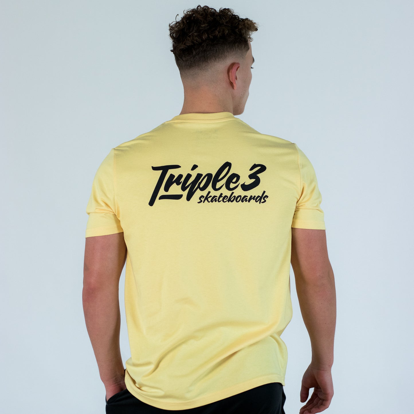 model wearing yellow triple 3 skateboards t shirt
